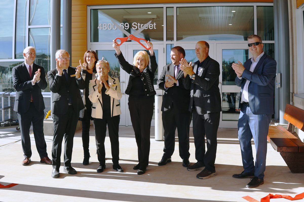 ribbon-cutting-group-Esther-raised-scissors-1200x800