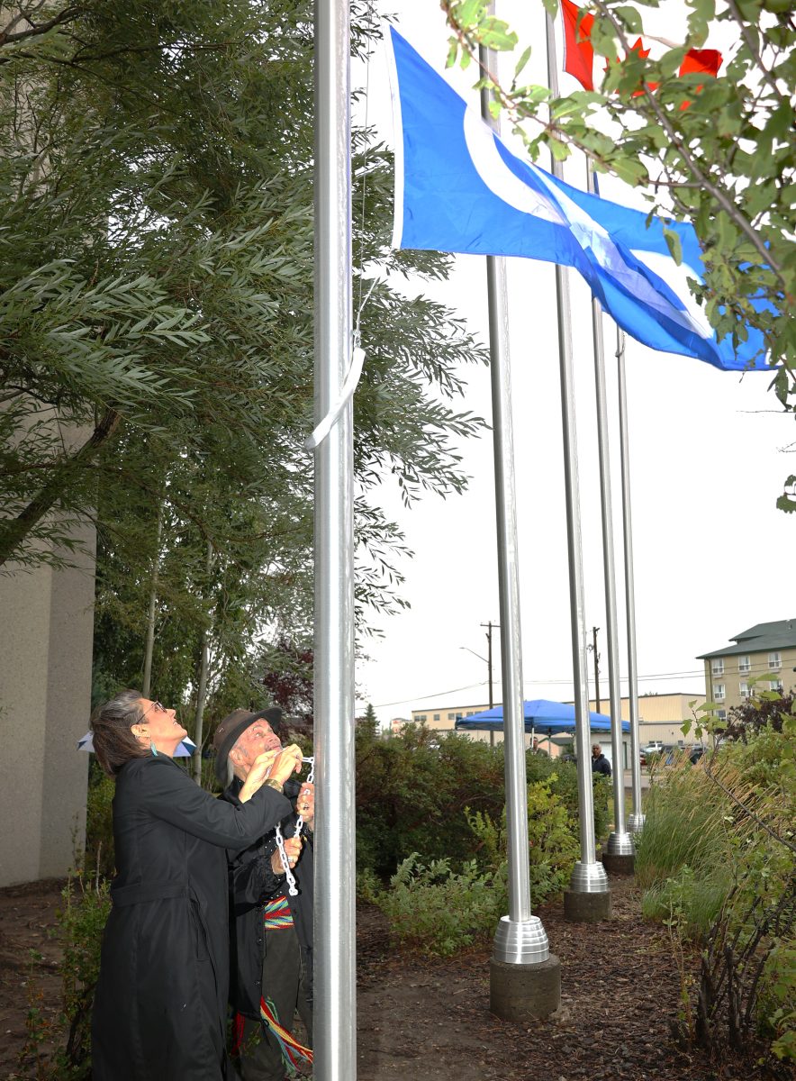 Elder-Terry-Lusty-and-Devonna-raise-Metis-Nation-flag-884x1200